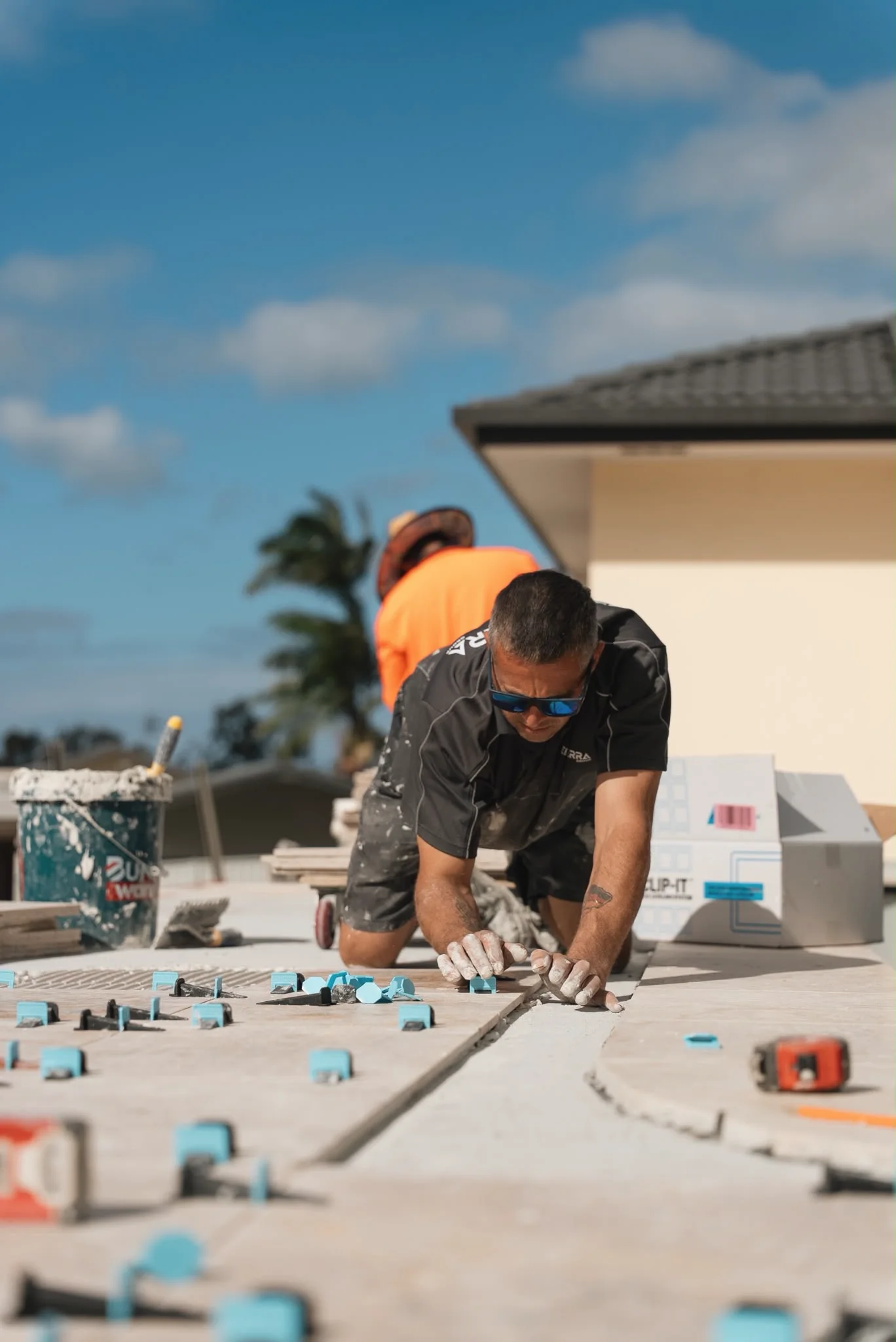 A Bella Terra crew member levelling travertine pavers with clips